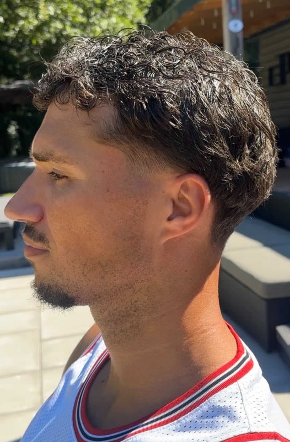 Krullend herenkapsel met taper fade, geknipt door Marcu(t)s